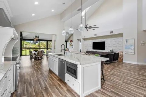a kitchen with a table chairs refrigerator and wooden floor
