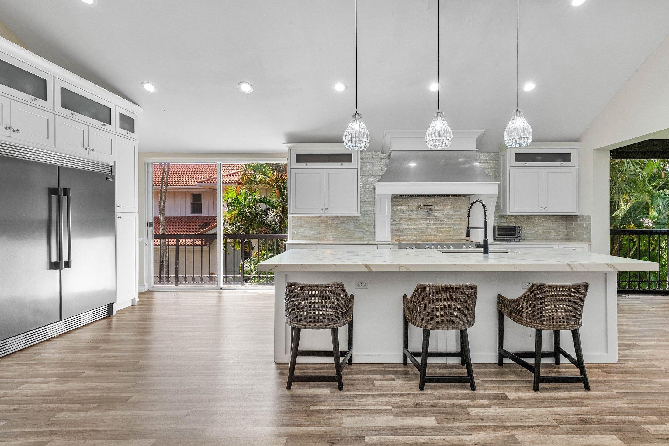 5887 Northwest 24th Avenue, Unit 1203 Boca Raton, FL 33496 - Photo 7 of 62 a kitchen with a table chairs refrigerator and wooden floor
