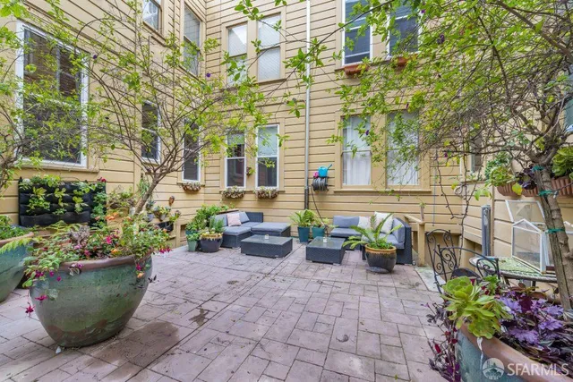 a view of a patio with chairs and potted plants