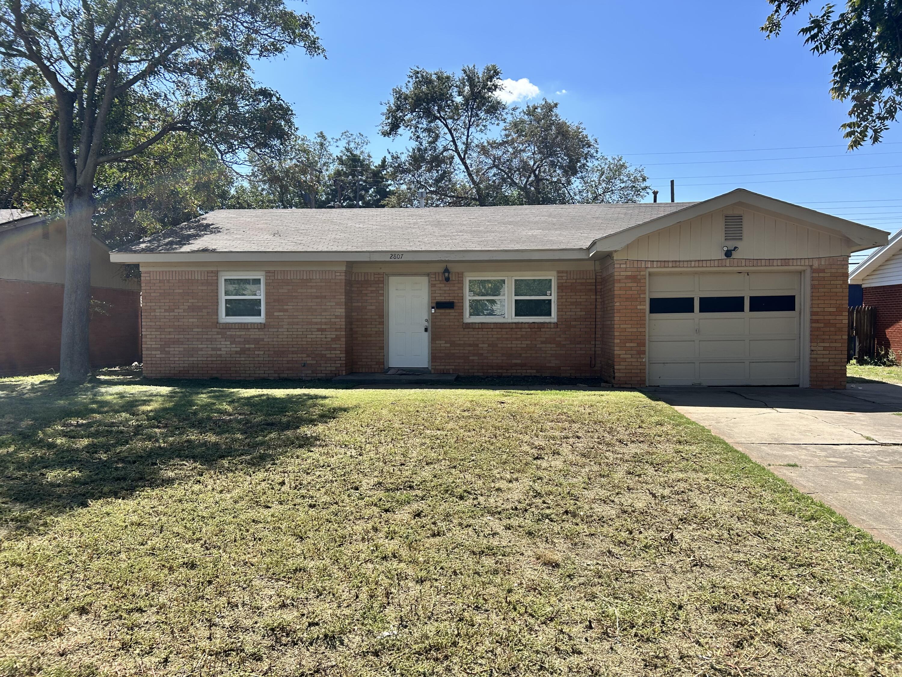 2807 60th Street Lubbock, TX 79413 - Photo 1 of 15 front view of a house with a yard