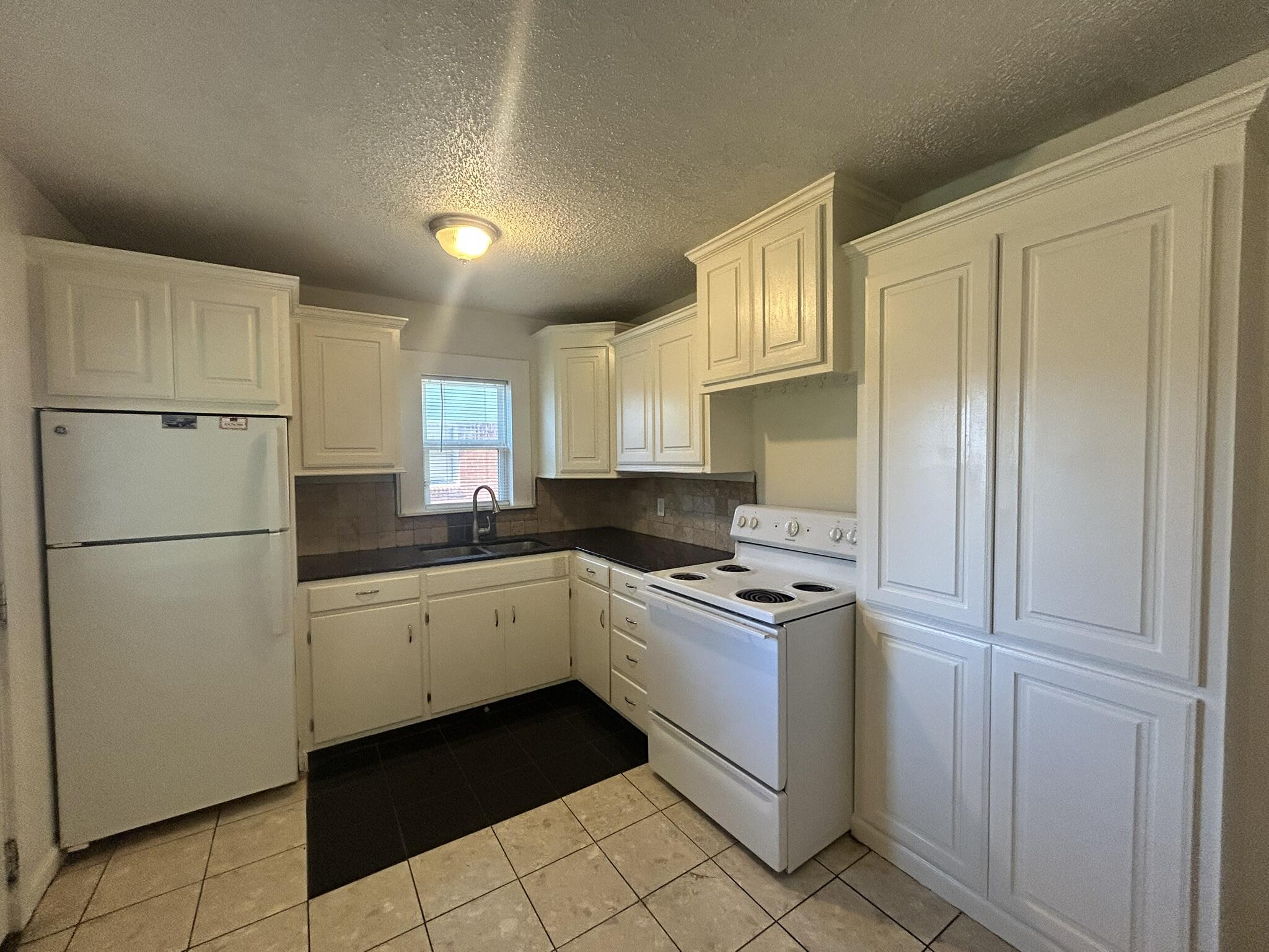 2807 60th Street Lubbock, TX 79413 - Photo 4 of 15 a kitchen with cabinets appliances and a window