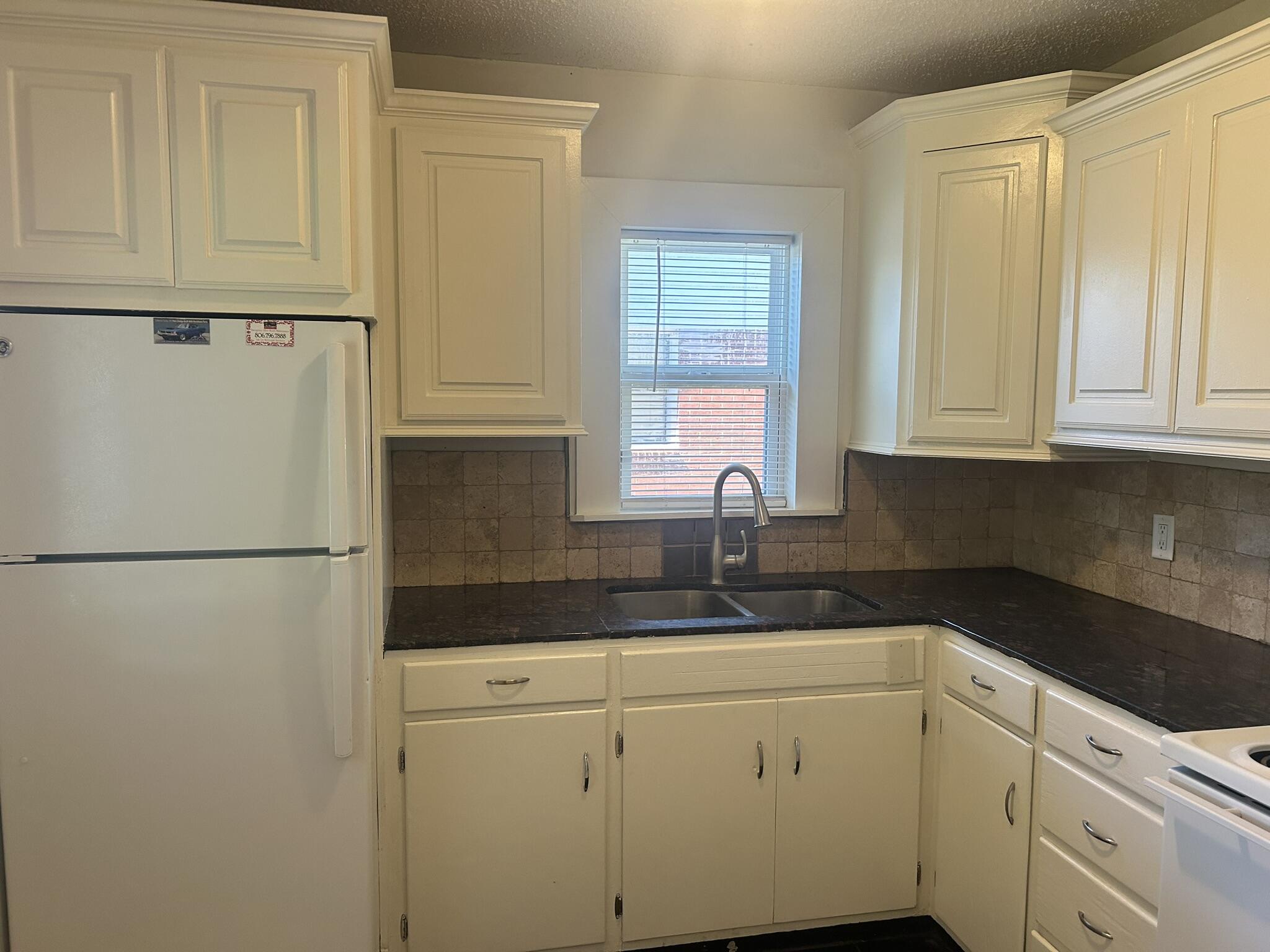 2807 60th Street Lubbock, TX 79413 - Photo 6 of 15 a white refrigerator freezer sitting inside of a kitchen