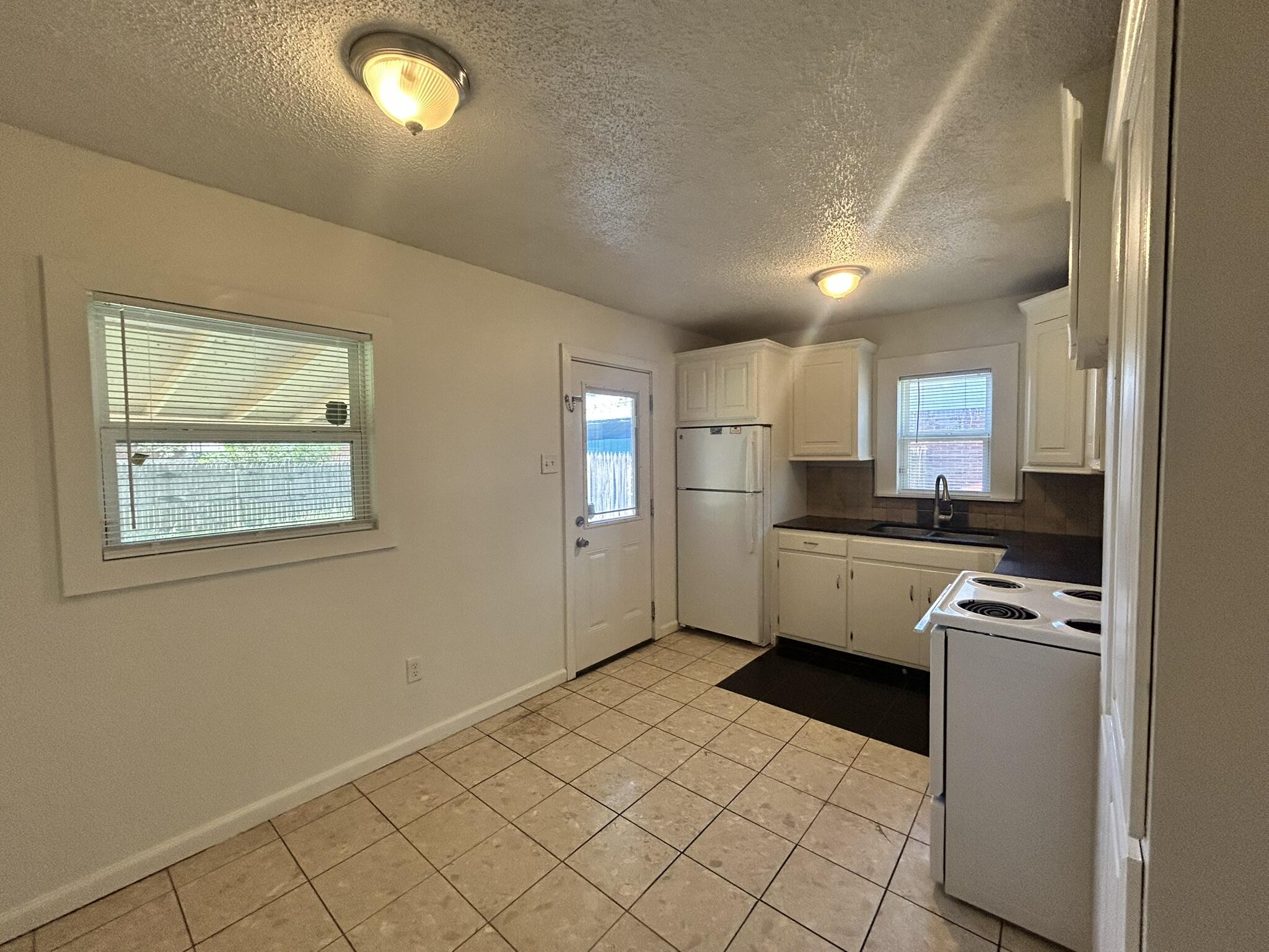 2807 60th Street Lubbock, TX 79413 - Photo 7 of 15 a kitchen with granite countertop a refrigerator and a stove top oven