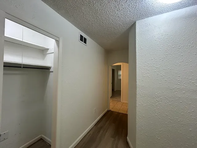 a view of a hallway with wooden floor
