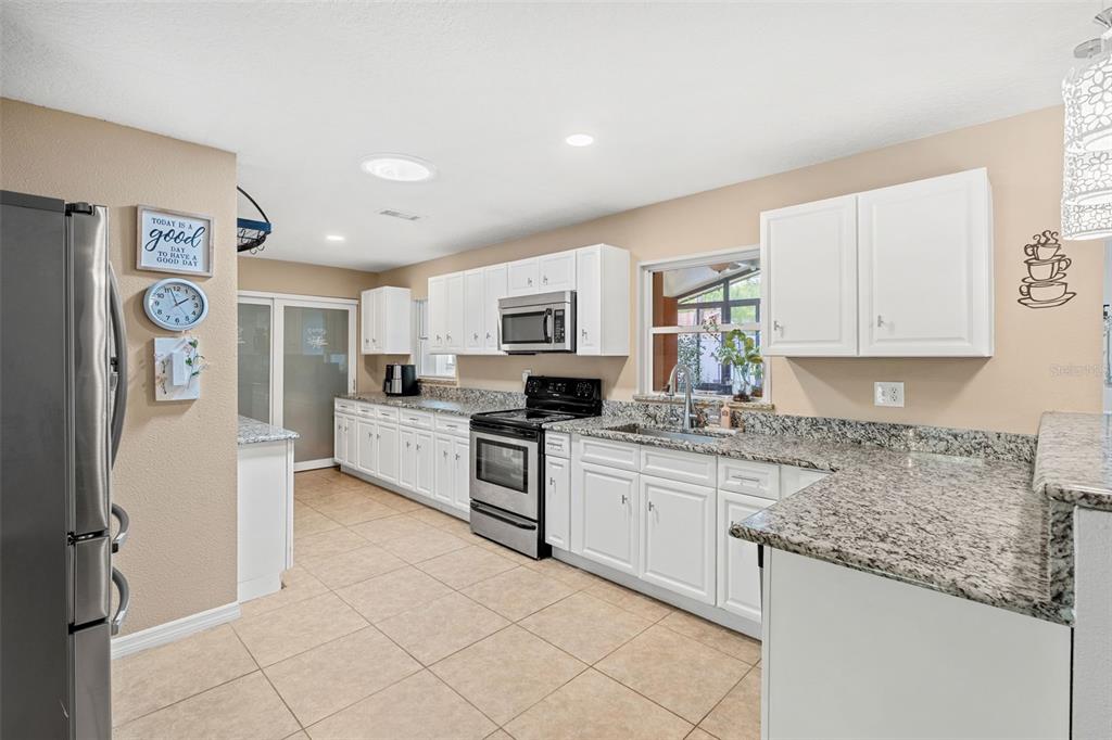 1702 Elaine Avenue Altamonte Springs, FL 32701 - Photo 16 of 39 a kitchen with stainless steel appliances granite countertop a refrigerator and a stove top oven