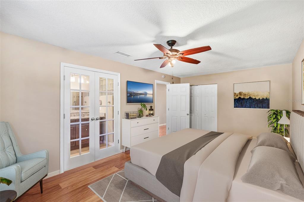 1702 Elaine Avenue Altamonte Springs, FL 32701 - Photo 22 of 39 a bedroom with a large bed a chandelier and a mirror