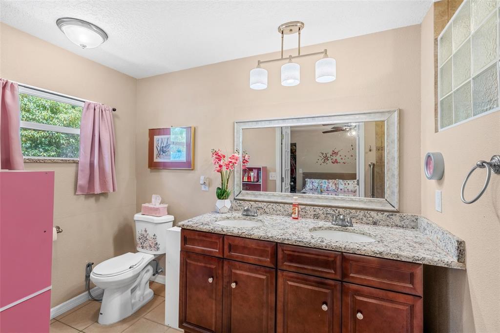 1702 Elaine Avenue Altamonte Springs, FL 32701 - Photo 23 of 39 a bathroom with a granite countertop sink mirror vanity and toilet