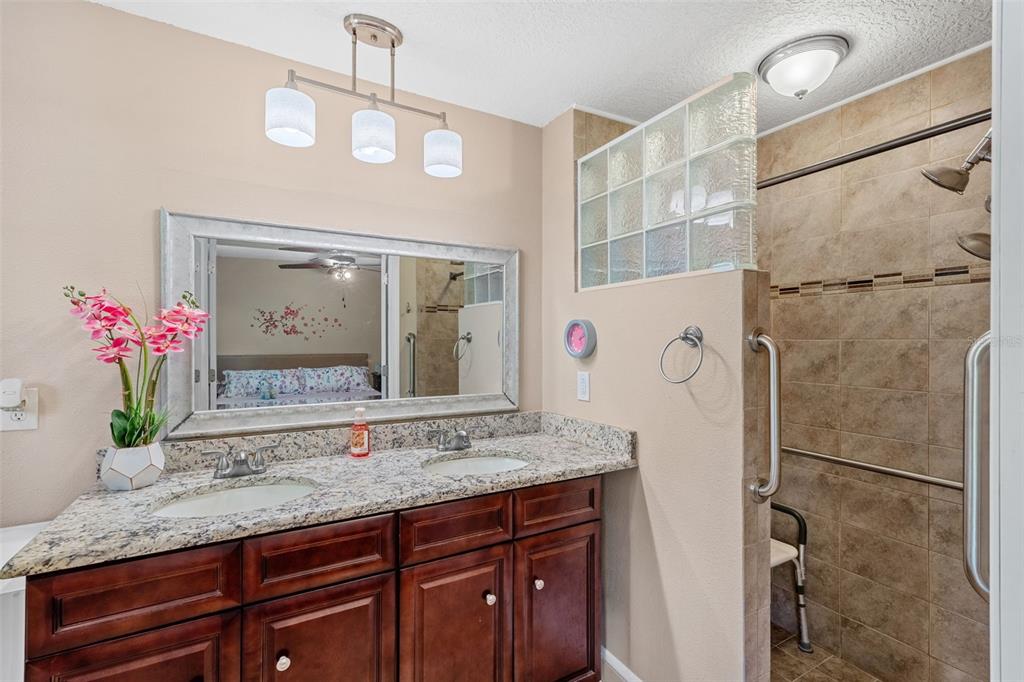 1702 Elaine Avenue Altamonte Springs, FL 32701 - Photo 24 of 39 a bathroom with a granite countertop shower a sink and a mirror