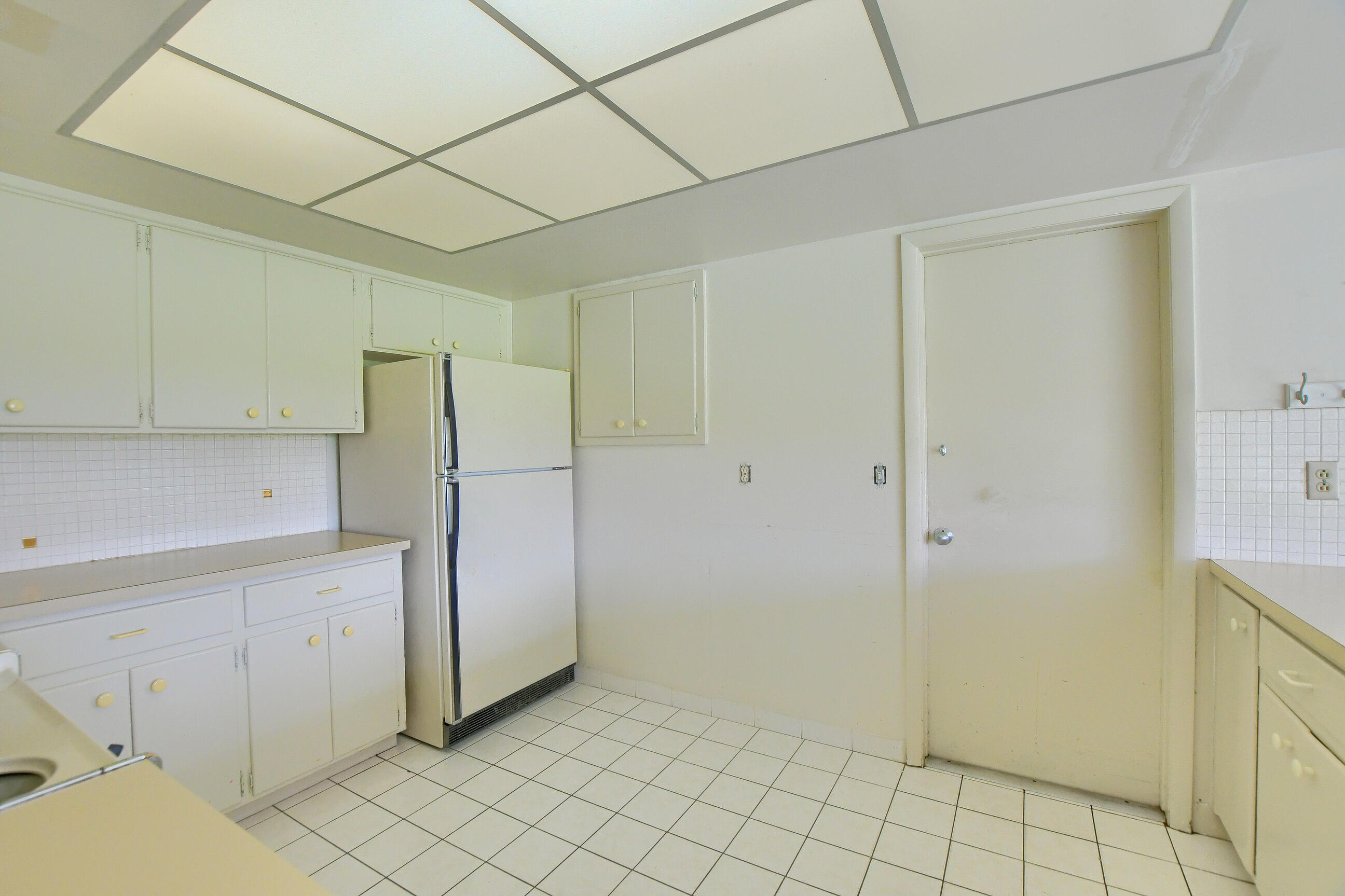 1099 Southwest 13th Place Boca Raton, FL 33486 - Photo 16 of 45 a view of a kitchen with white cabinets and a refrigerator