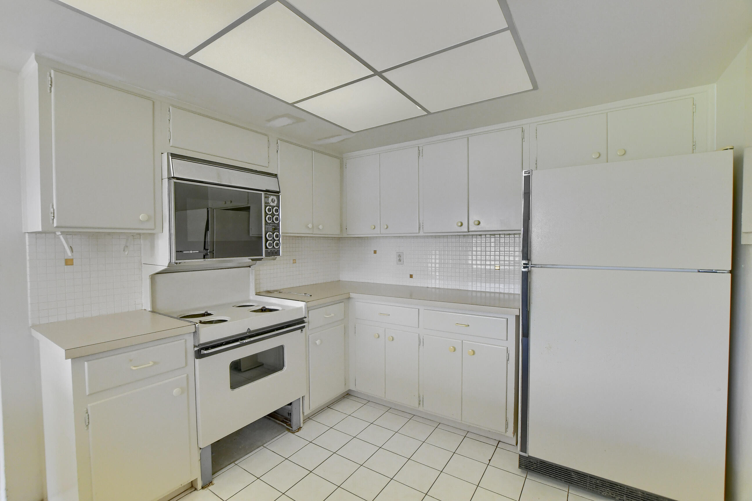 1099 Southwest 13th Place Boca Raton, FL 33486 - Photo 18 of 45 a kitchen with white cabinets and white appliances