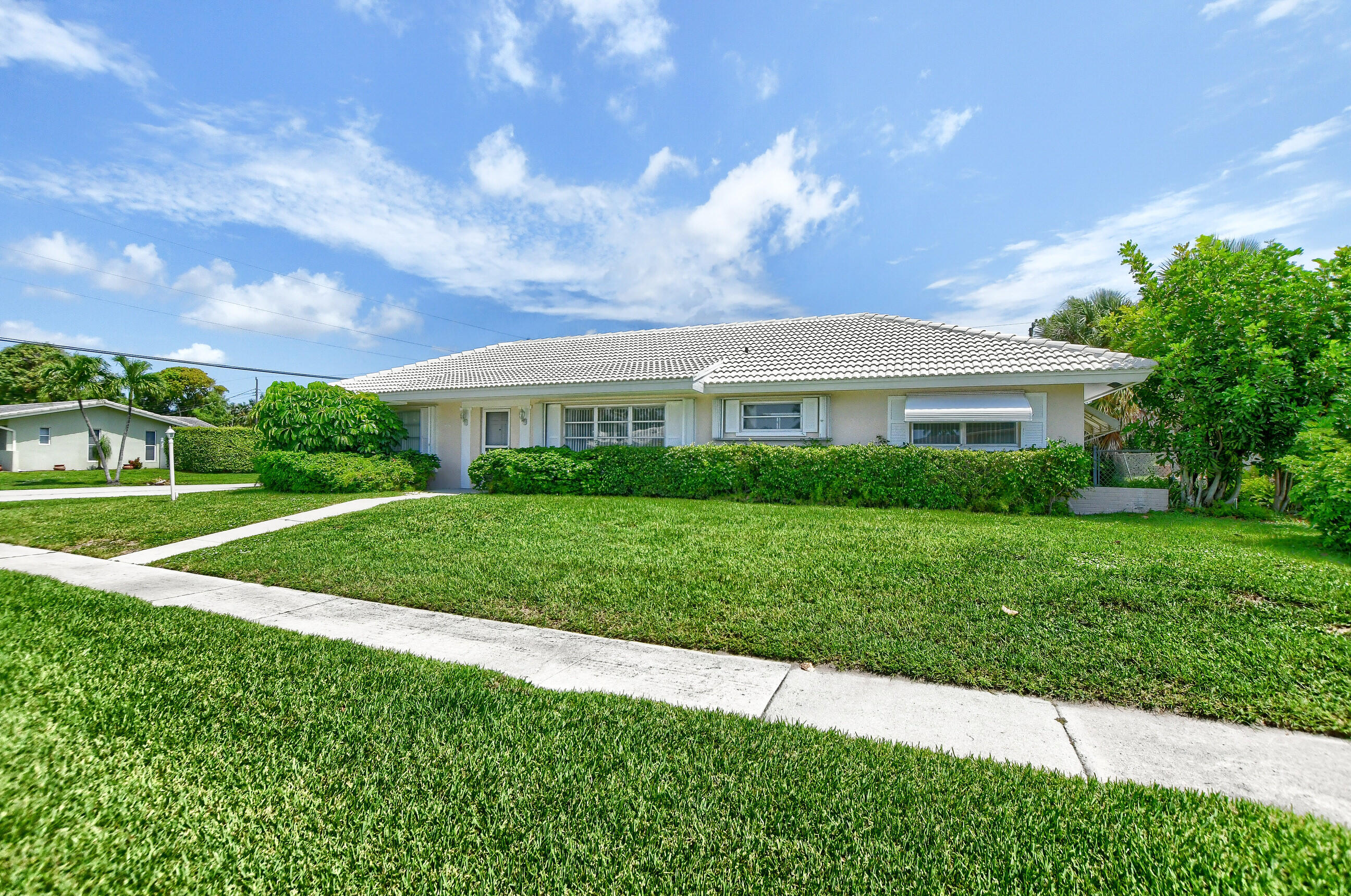 1099 Southwest 13th Place Boca Raton, FL 33486 - Photo 2 of 45 a view of house in front of a big yard with plants and large trees