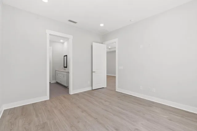 a view of a room with wooden floor and a bathroom