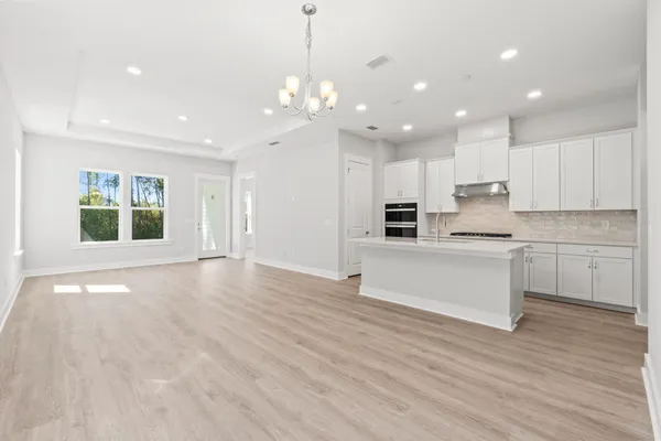 a view of a kitchen with a sink and dishwasher a kitchen island with wooden floor