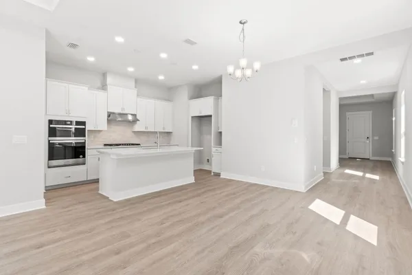 a view of a kitchen with kitchen island a sink stainless steel appliances and cabinets