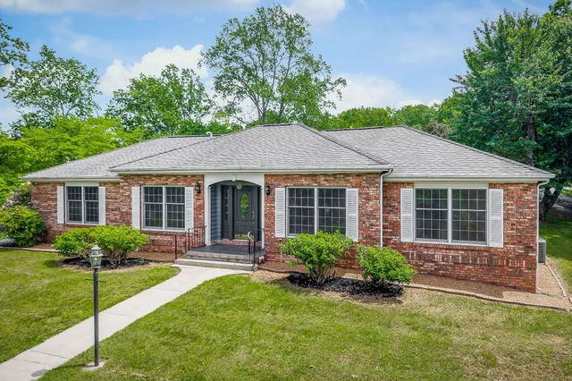 a view of a house with a yard and potted plants