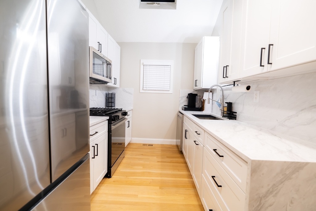 2 Turning Mill Lane, Unit 1 Quincy, MA 02169 - Photo 4 of 15 a kitchen with white cabinets and appliances