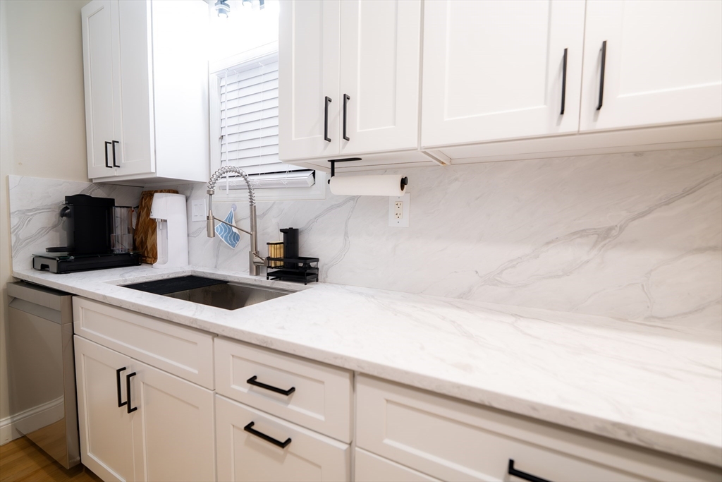 2 Turning Mill Lane, Unit 1 Quincy, MA 02169 - Photo 5 of 15 a kitchen with a white cabinets and sink