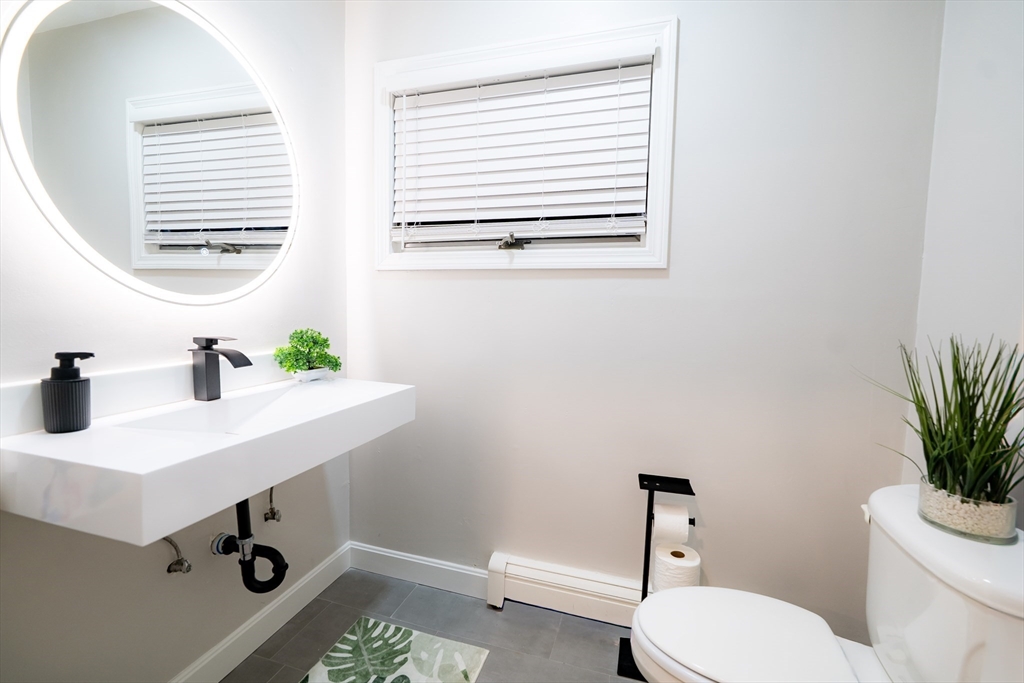 2 Turning Mill Lane, Unit 1 Quincy, MA 02169 - Photo 7 of 15 a bathroom with a sink a toilet and a window