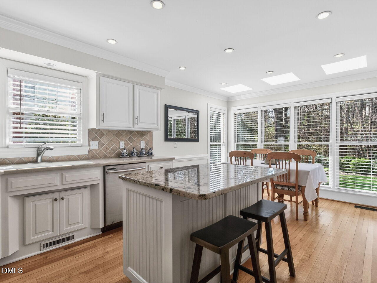1917 Hamrick Drive Raleigh, NC 27615 - Photo 5 of 23 a large kitchen with kitchen island granite countertop a dining table chairs and wooden floor