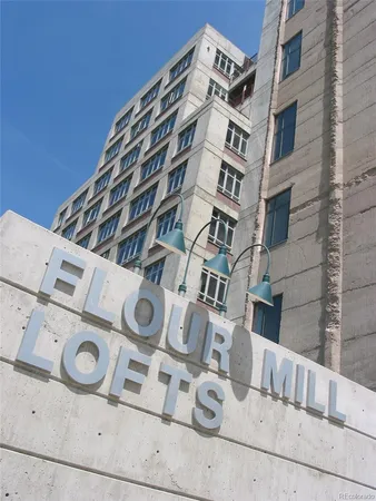 a front view of a building with a garden and plants