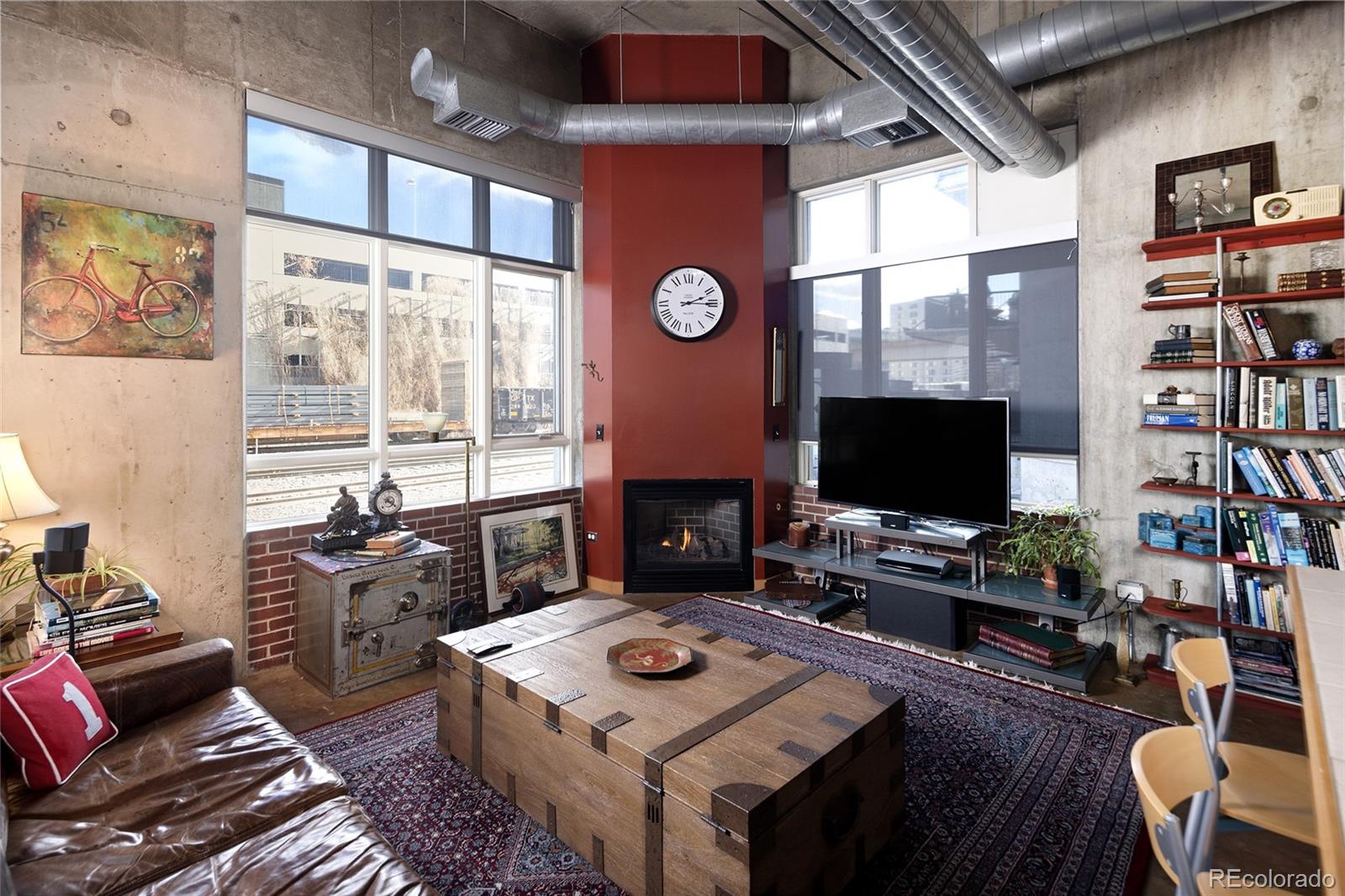 2000 Little Raven Street, Unit 102 Denver, CO 80202 - Photo 11 of 36 a living room with furniture a flat screen tv and a fireplace