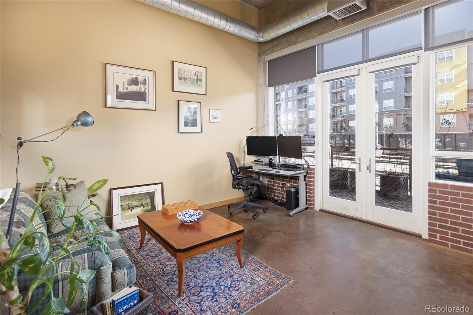 2000 Little Raven Street, Unit 102 Denver, CO 80202 - Photo 15 of 36 a living room with furniture a rug and a flat screen tv