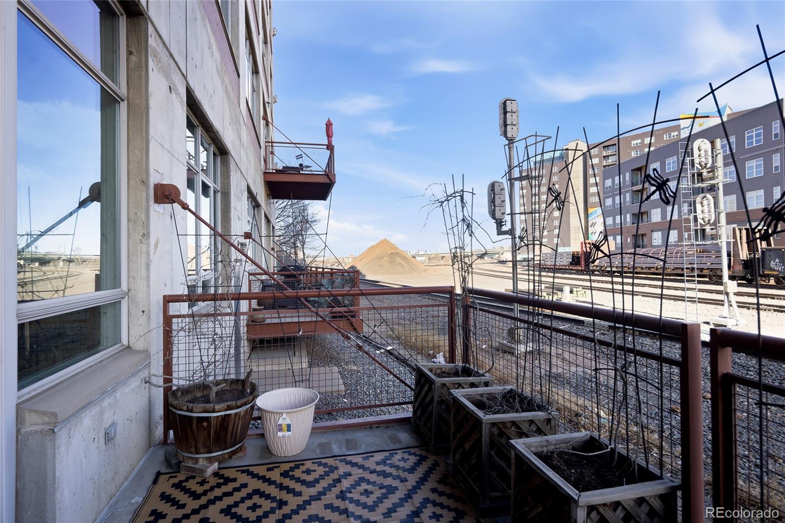 2000 Little Raven Street, Unit 102 Denver, CO 80202 - Photo 16 of 36 a view of balcony with two chairs and a stove
