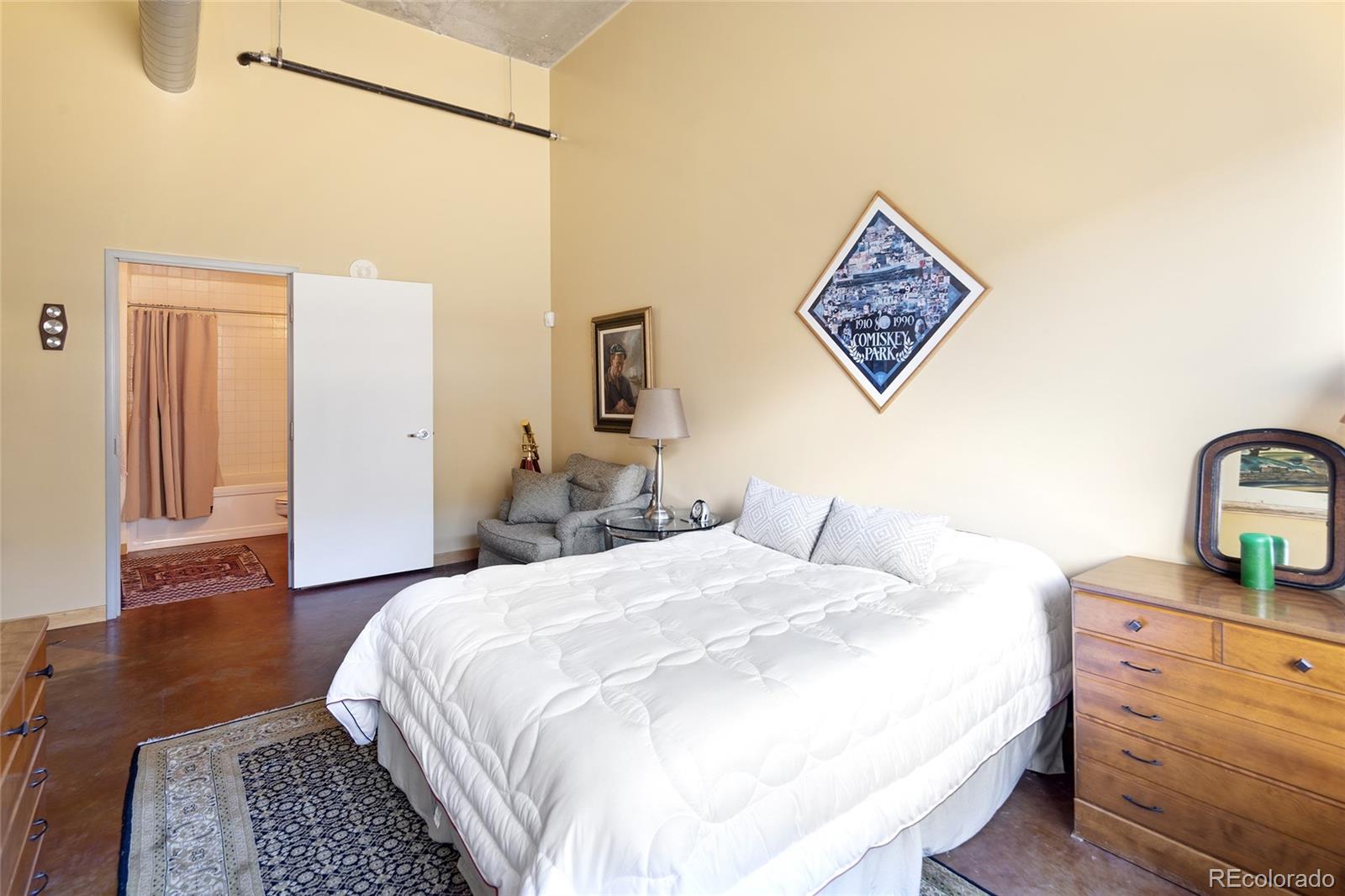 2000 Little Raven Street, Unit 102 Denver, CO 80202 - Photo 19 of 36 a bedroom with a bed and wooden floor