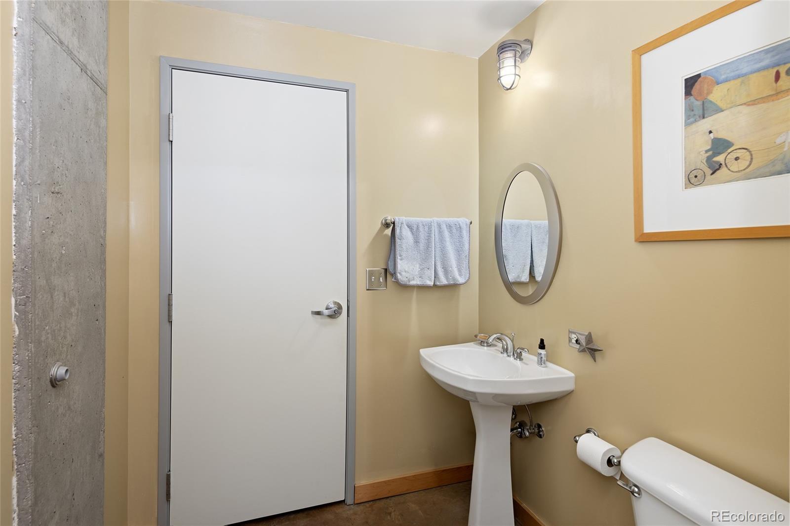 2000 Little Raven Street, Unit 102 Denver, CO 80202 - Photo 23 of 36 a bathroom with a sink a mirror and a toilet