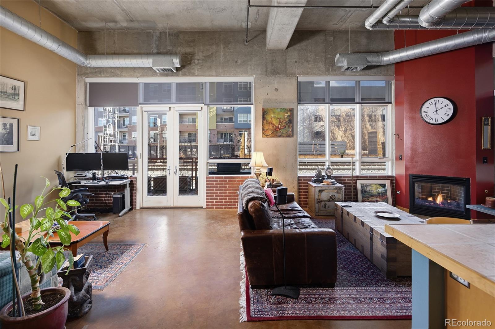 2000 Little Raven Street, Unit 102 Denver, CO 80202 - Photo 4 of 36 a living room with furniture a fireplace and a flat screen tv