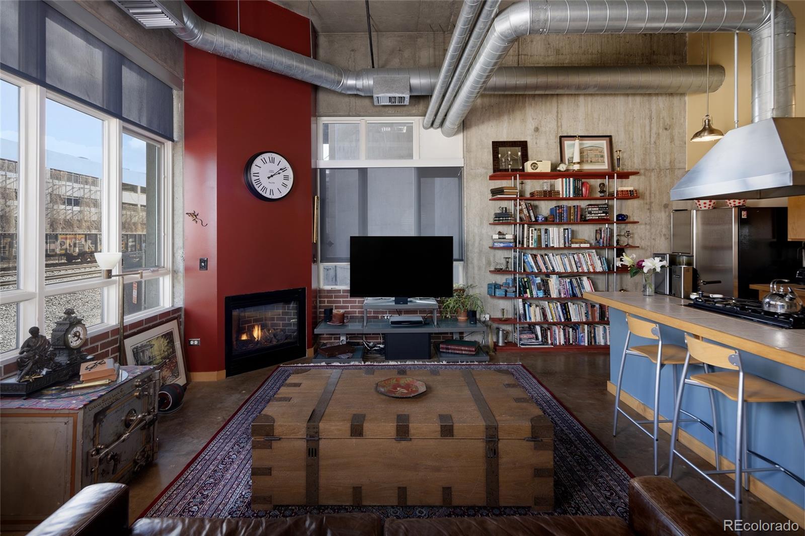 2000 Little Raven Street, Unit 102 Denver, CO 80202 - Photo 10 of 36 a kitchen with furniture a flat screen tv and a fireplace