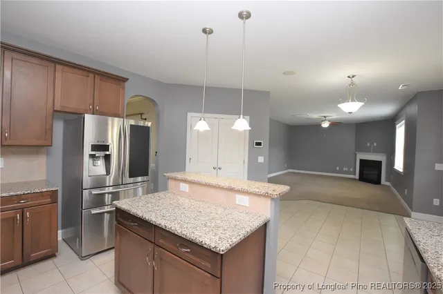 a kitchen with kitchen island a counter top space a sink appliances and cabinets
