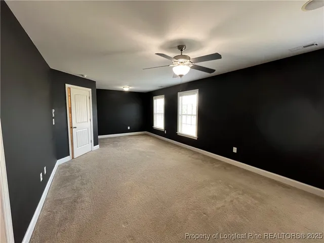 a view of an empty room with a ceiling fan
