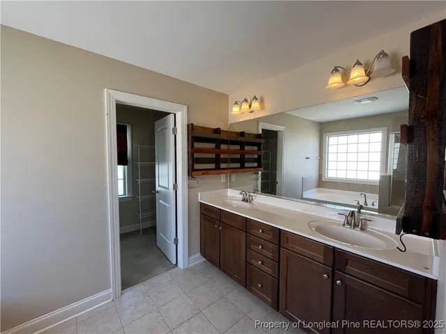 a spacious bathroom with a double vanity sink and a mirror