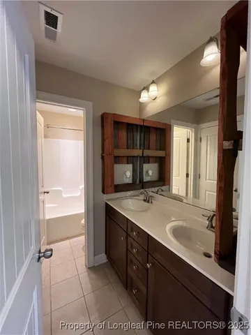 a bathroom with a sink double vanity and a large mirror