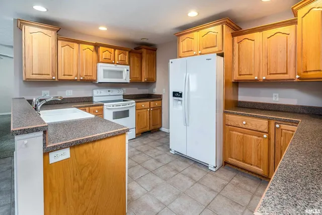 a kitchen with a refrigerator a stove top oven and cabinets