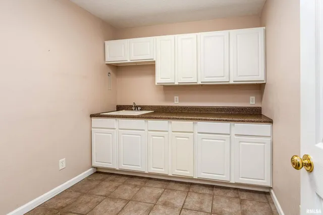 a kitchen with granite countertop white cabinets and sink