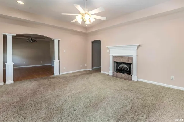an empty room with fireplace and fan