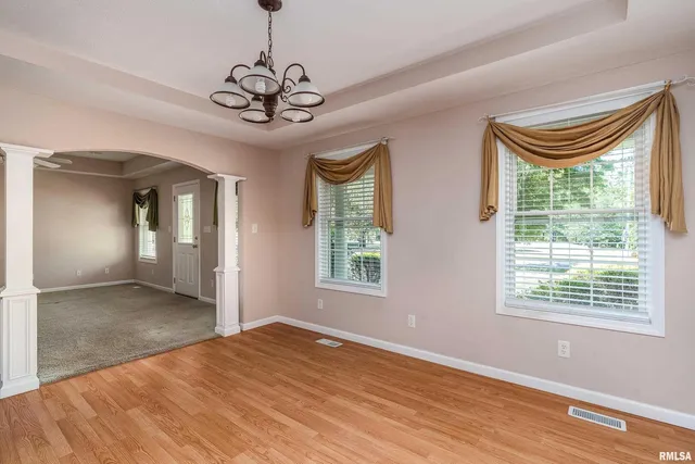 a view of empty room with window and wooden floor