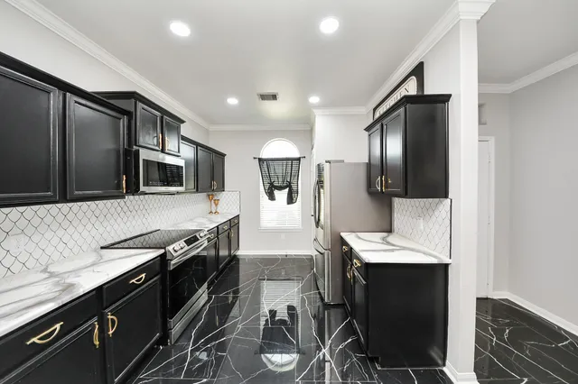 a kitchen with stainless steel appliances a sink stove and refrigerator