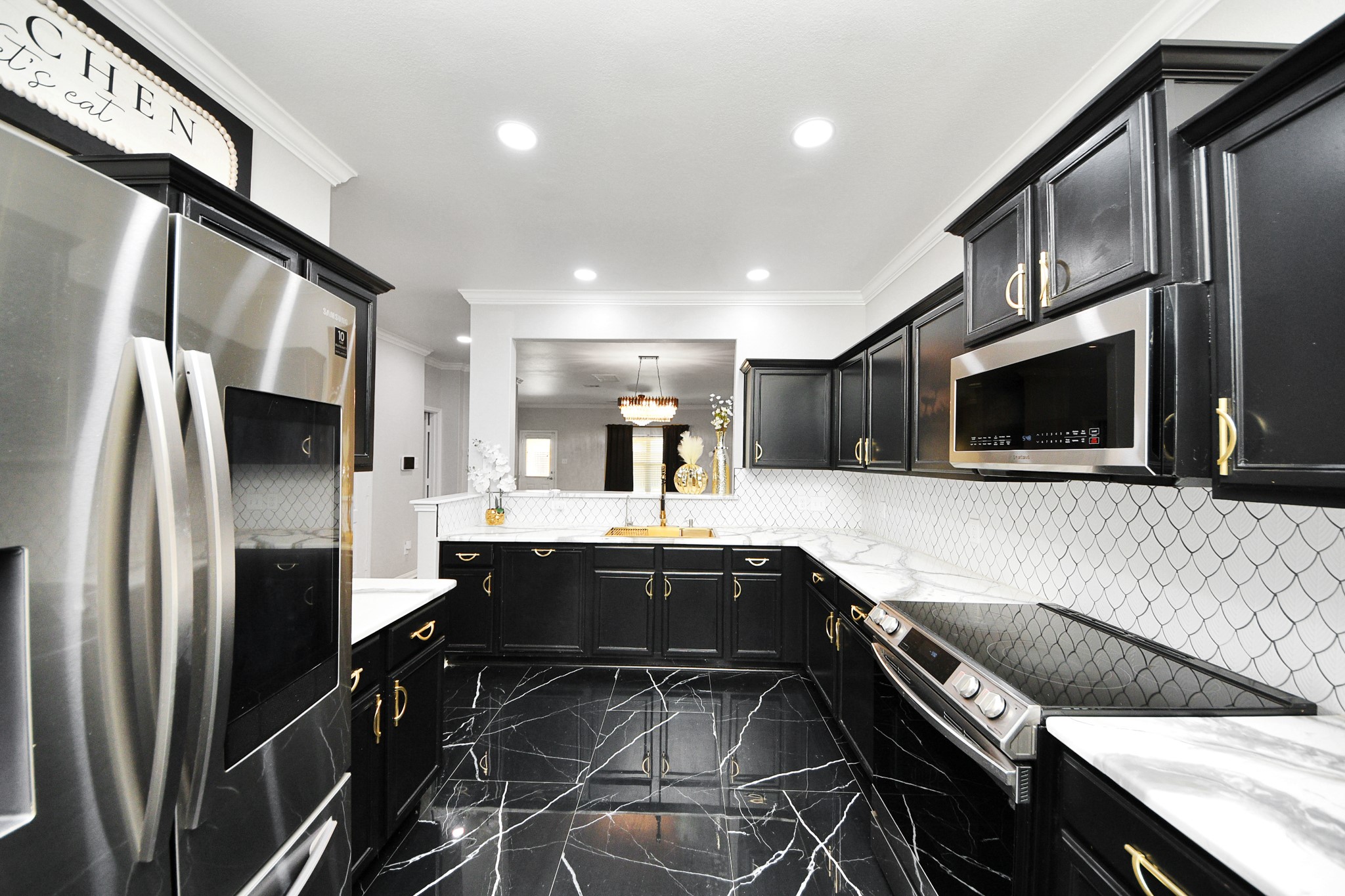 6931 Primrose Road Baytown, TX 77521 - Photo 9 of 50 a kitchen with stainless steel appliances kitchen island granite countertop a sink and stove top oven with wooden floor