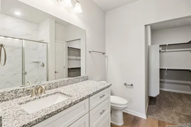 a bathroom with a granite countertop sink toilet and shower