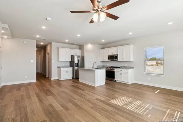 a view of kitchen with stainless steel appliances kitchen island wooden floor and window