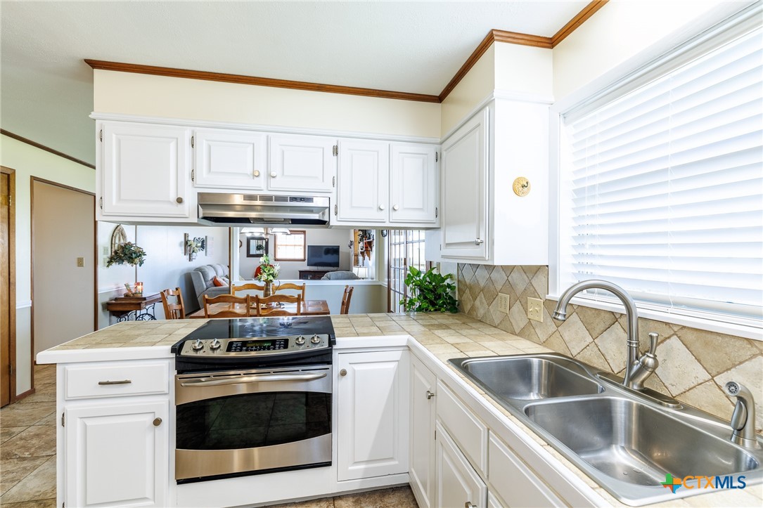 2110 Immenhauser Road Yoakum, TX 77995 - Photo 12 of 39 a kitchen with stainless steel appliances granite countertop a sink stove and cabinets