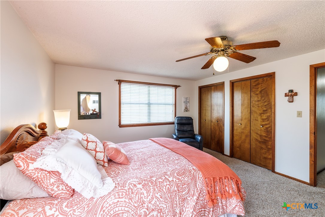 2110 Immenhauser Road Yoakum, TX 77995 - Photo 23 of 39 a bedroom with a bed and a chandelier
