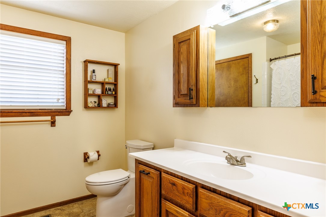 2110 Immenhauser Road Yoakum, TX 77995 - Photo 24 of 39 a bathroom with a sink toilet and vanity