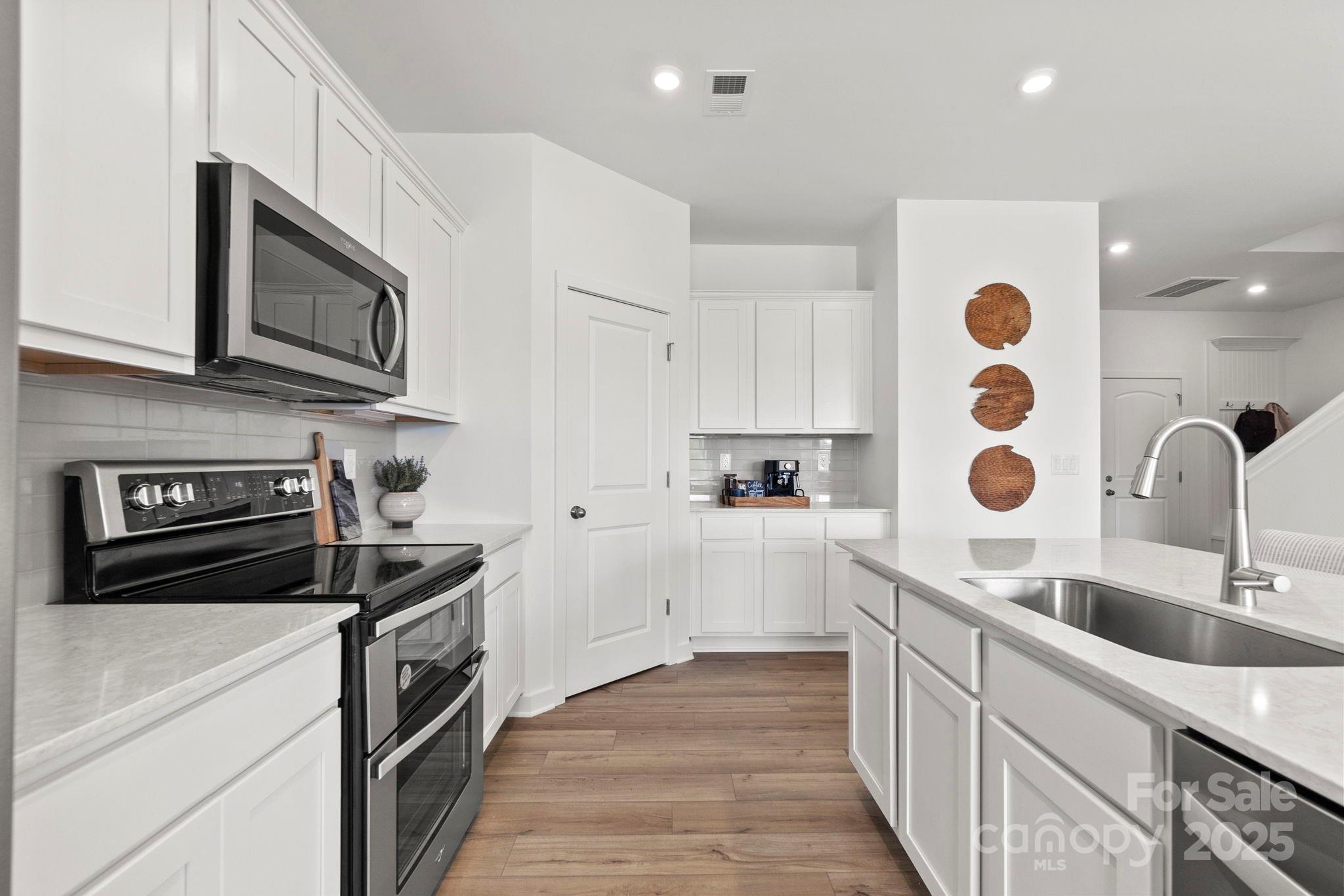 2573 Blue Sky Mdws Drive Monroe, NC 28110 - Photo 10 of 45 a kitchen with stainless steel appliances granite countertop a sink and a stove top oven