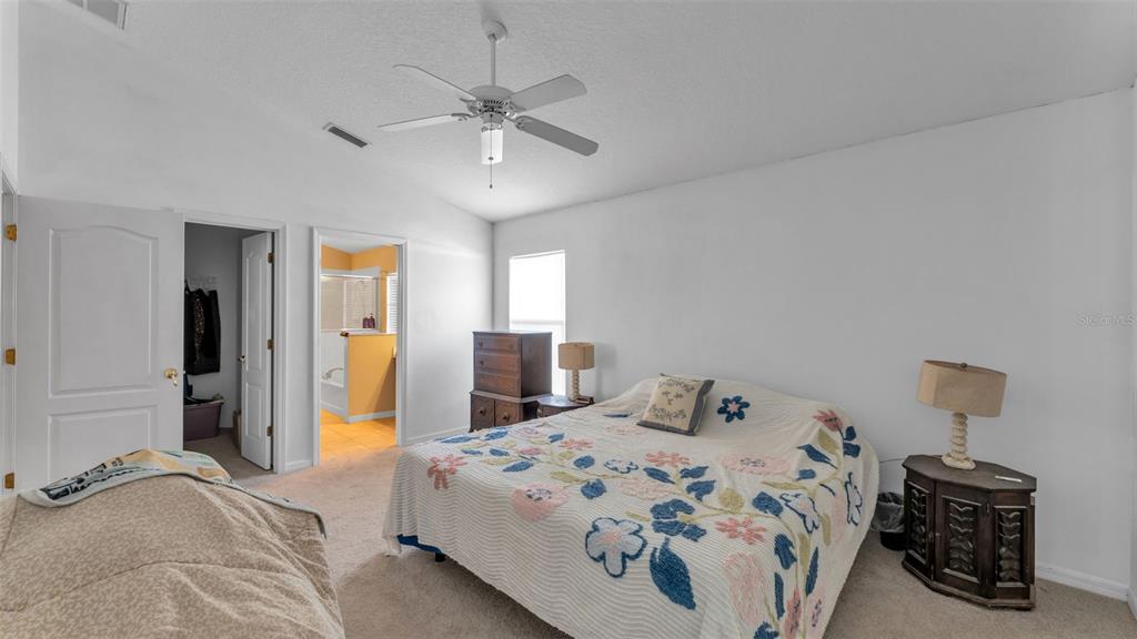 2729 Pankaw Lane Valrico, FL 33596 - Photo 15 of 41 a bedroom with a bed and a chandelier