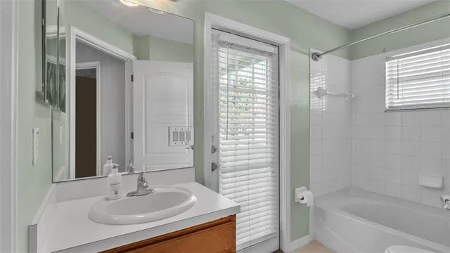 a bathroom with a granite countertop sink a mirror and a bathtub