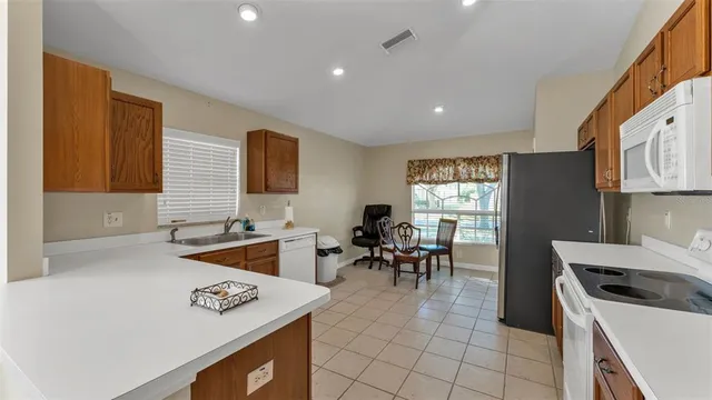 a kitchen with furniture a stove a sink a dining table and chairs